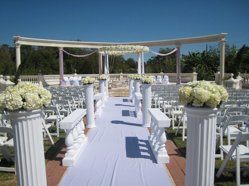 outdoor wedding chapel with white aisle runner and chairs