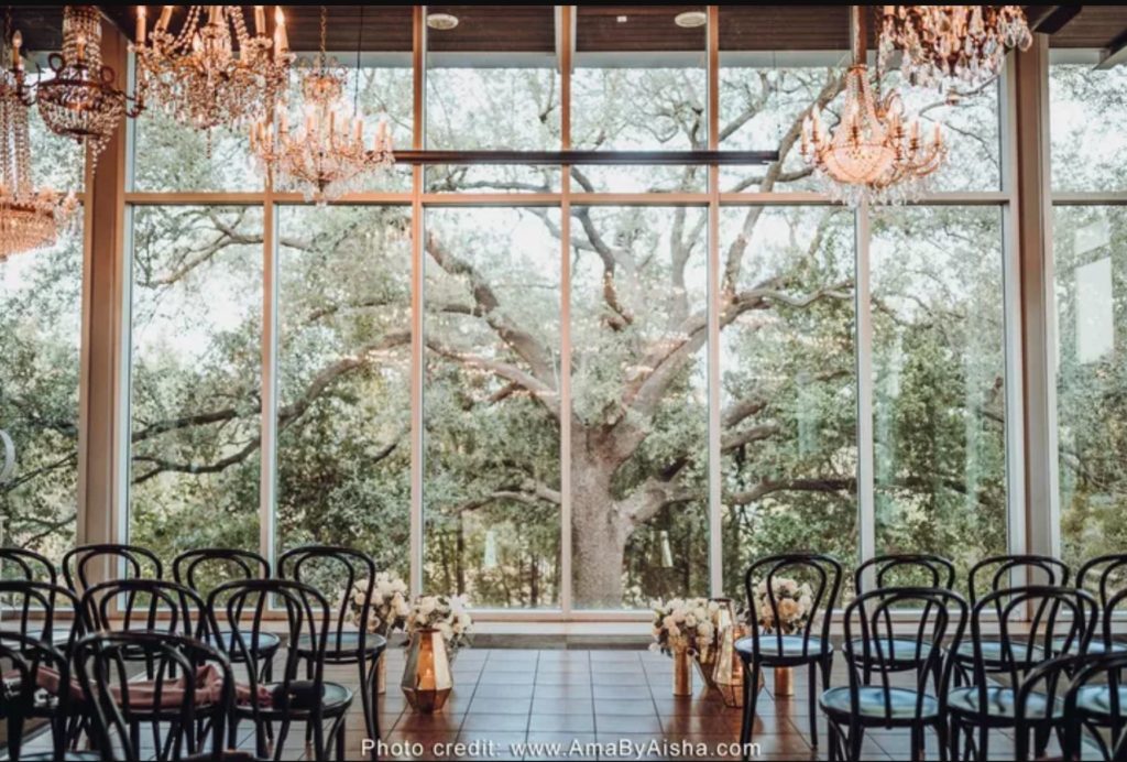 Wedding ceremony looking out at the trees outside The Dunlavy in Houston